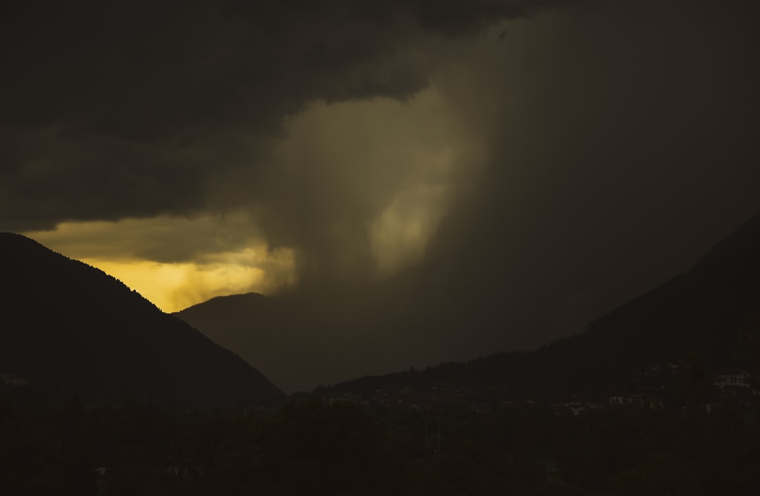 the sun is shining through the clouds over the mountains