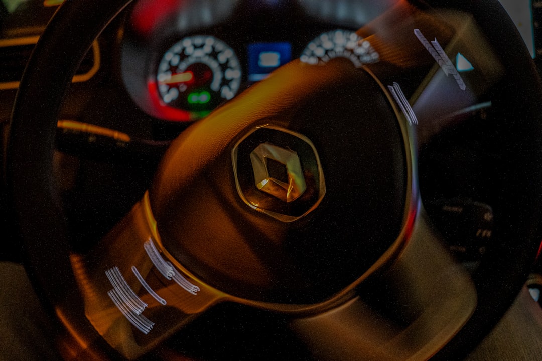 Close-up of a car's steering wheel with logo.