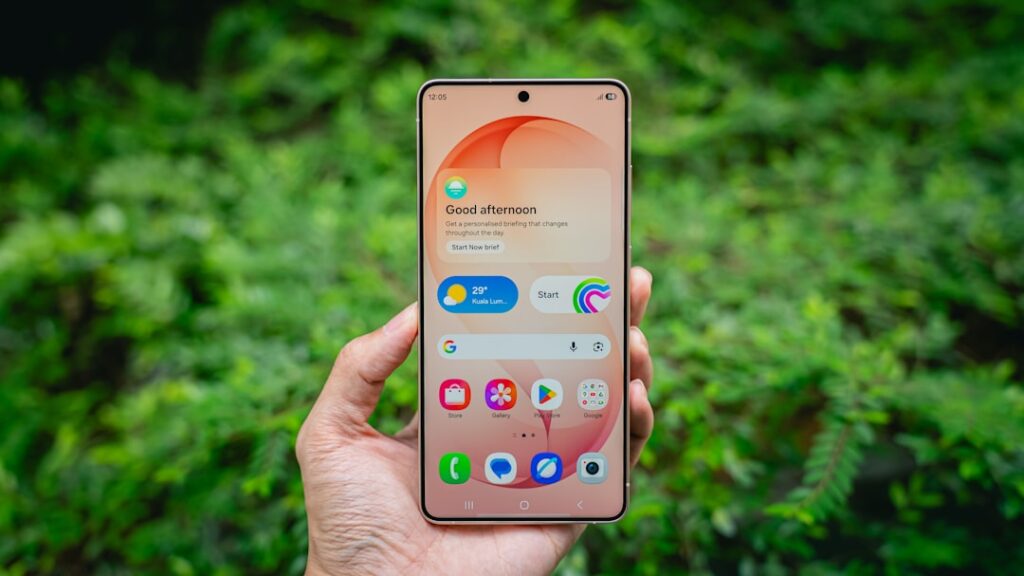 Hand holding a smartphone with colorful icons on-screen icons.