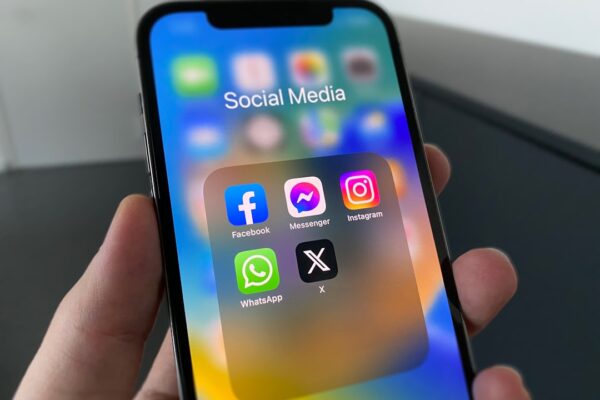 a person holding a cell phone with social media on the screen