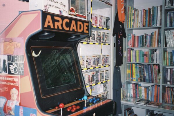 An arcade machine in front of a bookshelf